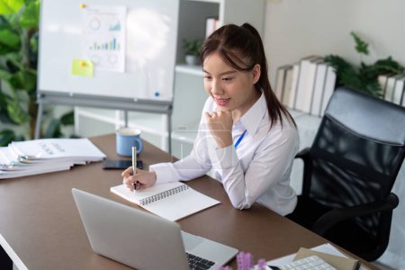 Foto de Mujer de negocios asiática usando portátil para analizar gráfico presupuesto financiero informe y planificación para el futuro en escritorio de oficina. - Imagen libre de derechos