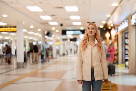 Foto de Feliz mujer turista asiática con equipaje viajando entre espera de vuelo en la terminal del aeropuerto, concepto de viaje turístico. - Imagen libre de derechos