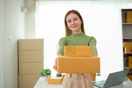 Photo for Young business woman asian working online ecommerce shopping at her shop. Young woman sell prepare parcel box of product for deliver to customer. Online selling. - Royalty Free Image