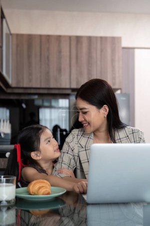Photo for Working mom work from home office. businesswoman and cute child using laptop work freelancer workplace in home, Lifestyle family moment. - Royalty Free Image