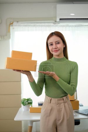 Photo for Young business woman asian working online ecommerce shopping at her shop. Young woman sell prepare parcel box of product for deliver to customer. Online selling. - Royalty Free Image