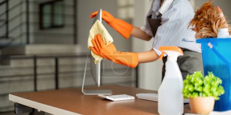 Photo for Woman clean in office room at office. Housekeeper or maid cleaner feel happy wipe mop and clean the work desk. the office office cleaning staff. - Royalty Free Image