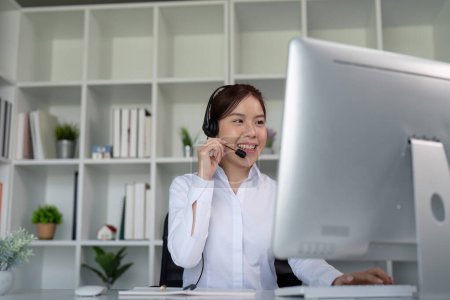 Téléchargez les photos : Centre d'appels femme sympathique asiatique au bureau pour le service à la clientèle, le soutien technique et les conseils, le contact et la communication avec l'opérateur du bureau d'assistance. - en image libre de droit