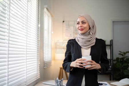 Téléchargez les photos : Femme d'affaires musulmane. femme d'affaires confiante musulmane en hijab debout avec les bras croisés près de son lieu de travail au bureau. - en image libre de droit