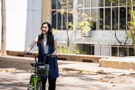 Foto de Eco amigable, estilo de vida feliz asiático hermosa joven mujer de negocios montar en bicicleta ir al trabajo de oficina en la calle de la ciudad con bicicleta en la mañana. - Imagen libre de derechos