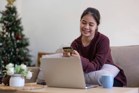 Foto de Mujer está haciendo la compra en línea. Chica está haciendo compras utilizando ordenador portátil y tarjeta de crédito para el pago en casa. - Imagen libre de derechos