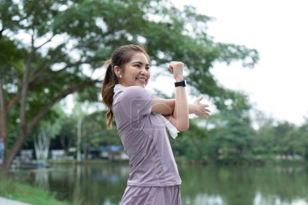 Photo for Woman asian doing stretch exercise stretch her arm, female stretch for warming up before running or workout in the park. - Royalty Free Image