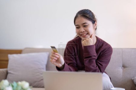 Photo for Young Asian woman hands holding credit card and using laptop for internet purchase. Online shopping, Online payment at home. - Royalty Free Image