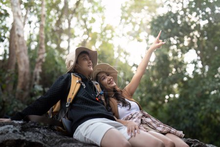 Téléchargez les photos : Charmant couple lesbienne femme avec sac à dos relaxant pendant la randonnée dans la nature. Aimer le moment romantique LGBT dans les montagnes. - en image libre de droit