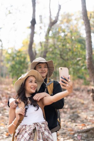 Photo for Lovely couple lesbian woman with backpack take a selfie while hiking in nature. Loving LGBT romantic moment in mountains. - Royalty Free Image