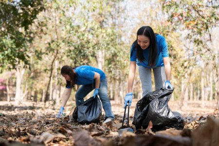 Téléchargez les photos : Volontaire ramassant des déchets en plastique dans la forêt. Le concept de conservation de l'environnement. Pollution de l'environnement mondial. Nettoyage de la forêt. - en image libre de droit
