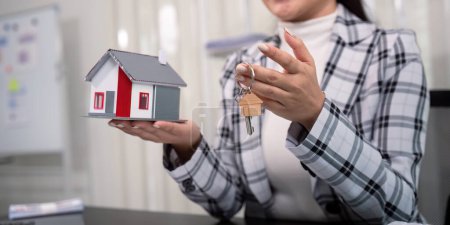 Téléchargez les photos : Agent immobilier avec modèle de maison et clé
. - en image libre de droit