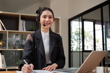 Photo for Call center agent with headset working on support hotline in office. Video conference. - Royalty Free Image