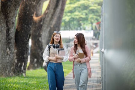 Photo for University student girl friends with learning book college while walking in campus. - Royalty Free Image