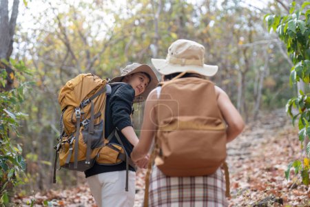 Photo for Happy LGBT lesbian couple travel enjoy hiking with backpack in forest trail. - Royalty Free Image