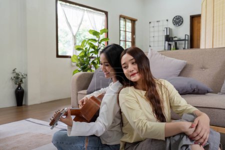 Photo for Asian young lover lesbian couple playing guitar with relax and happy moment in living room LGBT relationship in lifestyle concept. - Royalty Free Image