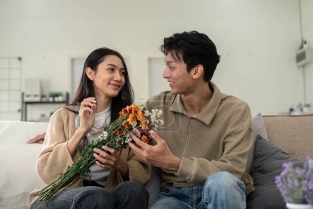 Jeune couple appréciant les fleurs à la maison. Concept d'amour, de compagnie et de bonheur.