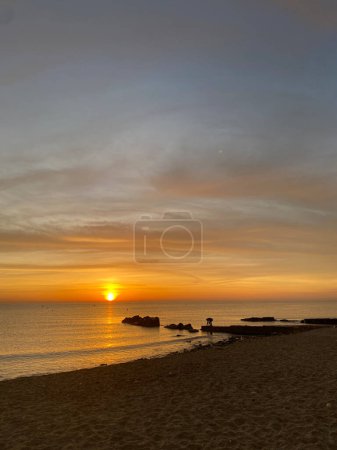 Photo for Taking pictures of the sunrise in the Mediterranean. Photographer on the Valencian coast photographing the sunrise. Spectacular and colorful sky. - Royalty Free Image