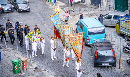 Téléchargez les photos : 22 avril 2022-procession avec des gens vêtus de blanc dans la rue à Naples portant de nombreuses bannières religieuses - en image libre de droit