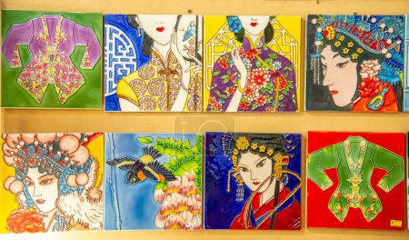 Téléchargez les photos : Square porcelain tiles painted with brightly coloured faces of Asian women - en image libre de droit