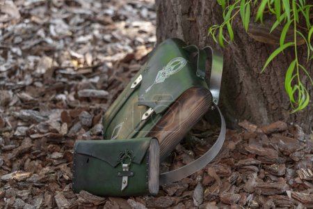 Photo for Green leather bag-backpack with a purse, against the background of tree bark - Royalty Free Image