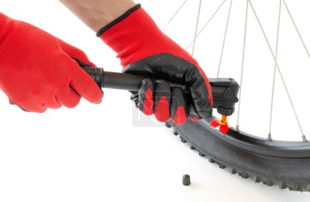 Foto de Inflate a flat tire of a bicycle with a hand pump, close-up, on an isolated white background - Imagen libre de derechos