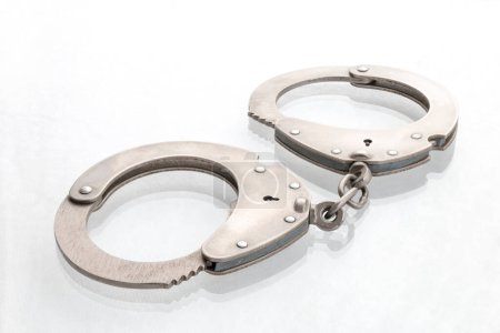 Photo for Pair of steel handcuffs close up, Silver metal handcuffs on white - Royalty Free Image
