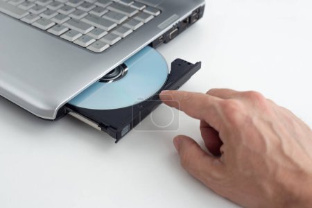 Foto de Inserta disco DVD en el ordenador portátil, concepto de grabación de datos a DVD en el aislamiento de fondo - Imagen libre de derechos
