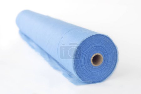 Téléchargez les photos : Un rouleau de tissu bleu, un drap pour massage, sur fond blanc. - en image libre de droit