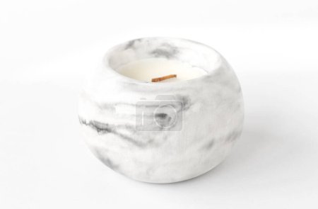 scented candle with a wooden wick in a plaster candlestick, close-up on a white background
