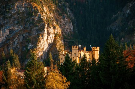 Téléchargez les photos : Une image saisissante du château de Hohenschwangau, niché dans les Alpes bavaroises en Allemagne. Les murs et les tours du château créent un contraste saisissant avec les rochers et le feuillage d'automne - en image libre de droit