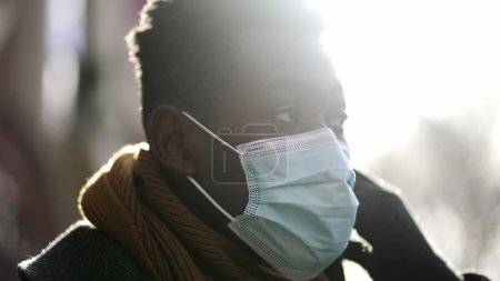 Photo for Black man removing covid surgical face mask, end of pandemic concept feeling relief and fresh air - Royalty Free Image