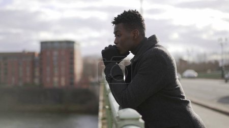 Photo for Elegant Contemplative African man looking at horizon wearing winter clothes - Royalty Free Image