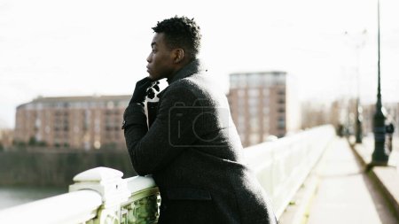 Photo for Elegant Contemplative African man looking at horizon wearing winter clothes - Royalty Free Image