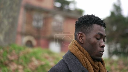 Téléchargez les photos : Pensive young black African man standing outside thinking - en image libre de droit
