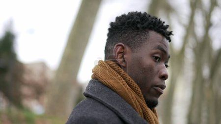 Téléchargez les photos : Pensive young black African man standing outside thinking - en image libre de droit