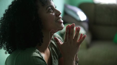 Foto de Mujer sudamericana teniendo ESPERANZA mirando hacia arriba con FE. Una chica latina negra agradecida en oración - Imagen libre de derechos