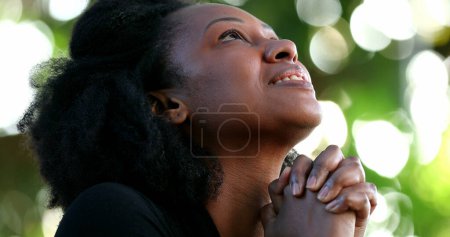 Mujer africana sintiéndose esperanzada y espiritual. Persona fiel con ESPERANZA y FE