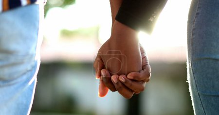 Téléchargez les photos : Couple noir tenant la main à l'extérieur pendant l'heure dorée coucher de soleil - en image libre de droit