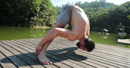 Foto de Entrenamiento Fit Man Yoga al aire libre. Cuerpo de elevación de la persona con parte superior del cuerpo - Imagen libre de derechos