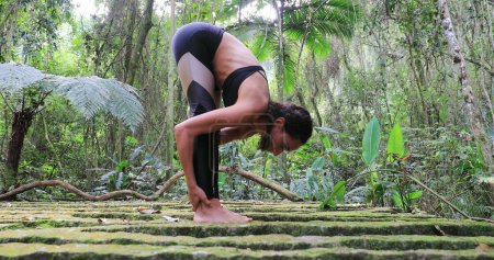 Photo for Yogi woman stretching legs outdoors in tropical jungle - Royalty Free Image