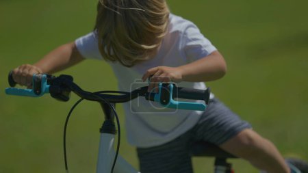 Photo for One small boy pushing bicycle child climbing on bike riding - Royalty Free Image