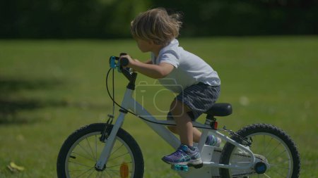 Photo for Little boy getting off bicycle pushing bike active child - Royalty Free Image