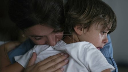 Foto de Madre abrazando y acariciando al niño. Los padres consuelan llorando niño pequeño. Maternidad amor y afecto concepto - Imagen libre de derechos