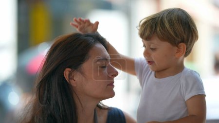 Photo for Child hitting mother head outside. Mom having patience. Parent tolerating little boy behavior. Parenting stress concept - Royalty Free Image
