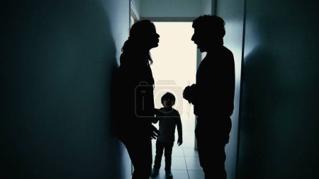 Foto de Padres enojados peleando delante de su hijo pequeño. Discusión sobre relaciones abusivas. Esposo golpeando esposa de pie en el pasillo en la oscuridad - Imagen libre de derechos