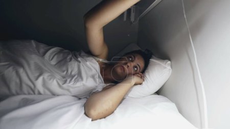 Téléchargez les photos : La femme va dormir en éteignant la lampe de nuit. La personne éteint la lumière - en image libre de droit