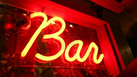Téléchargez les photos : Bar enseigne fluorescente Lumière qui brille la nuit dans la porte d'entrée. Red Bar entreprise de publicité brille dans l'obscurité - en image libre de droit