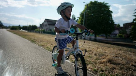Photo for Active child learning to ride bike. Kid loses equilibrium balance while riding bicycle. - Royalty Free Image
