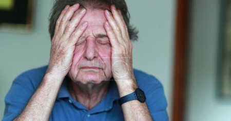 Téléchargez les photos : Older man covering face with hands, stressed and tired senior man in 70s feeling pressure - en image libre de droit